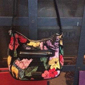 Purse with black shoulder strap in multi colored print
